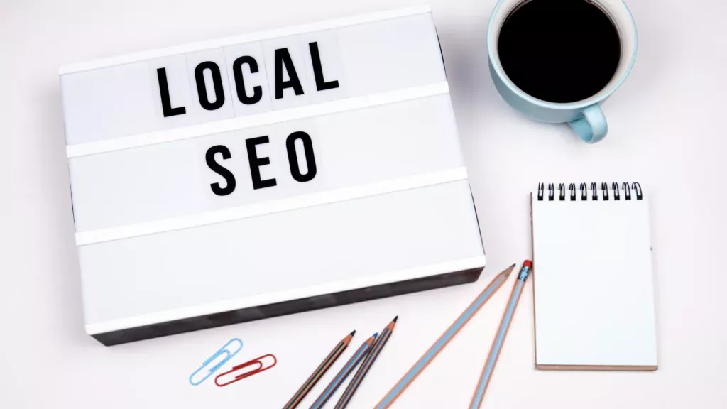 A lightbox displaying the text "LOCAL SEO" on a desk with office supplies, symbolizing Local SEO for service businesses.
